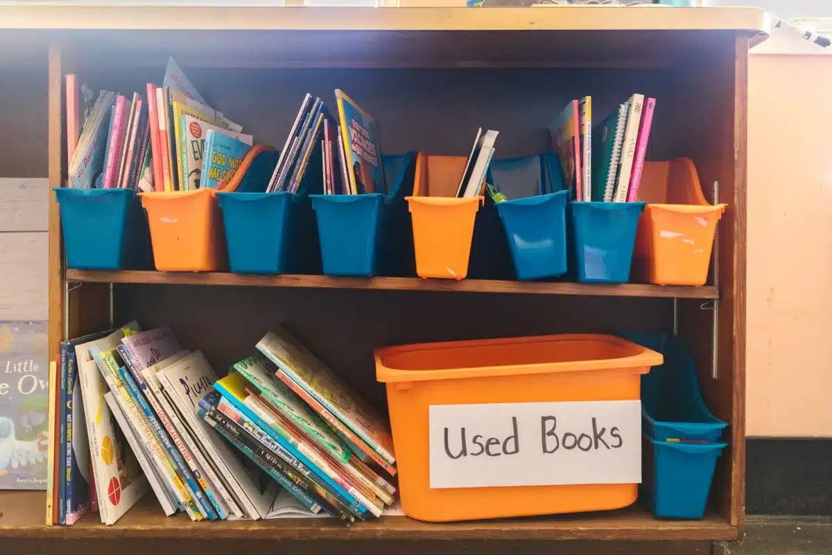 Étagères basses avec contenants transparents et étiquettes visuelles dans une classe maternelle