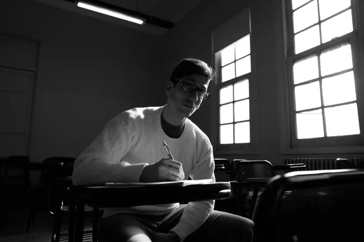 Élève écrivant et dessinant pour exprimer ses idées en classe.