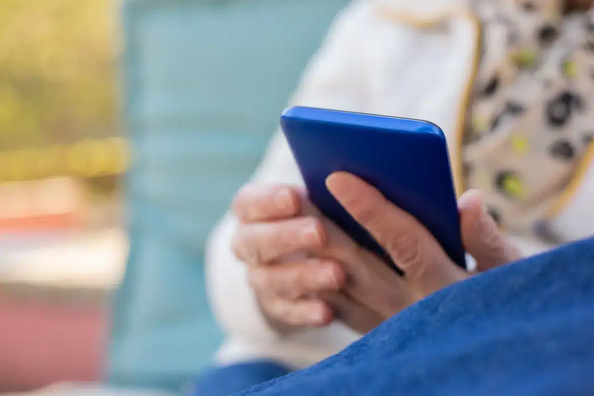 Personne consultant les réseaux sociaux sur un téléphone portable