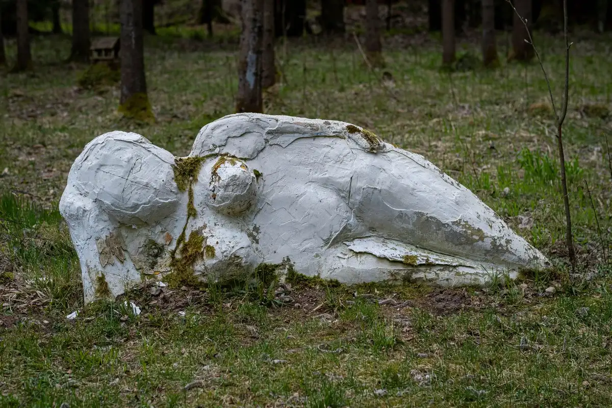 Site touristique abandonné avec statue géante et équipements de construction en arrière-plan