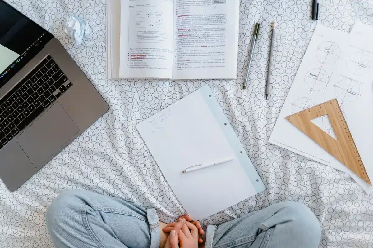 Enseignant organisant des ressources pédagogiques et des grilles d'observation sur un bureau