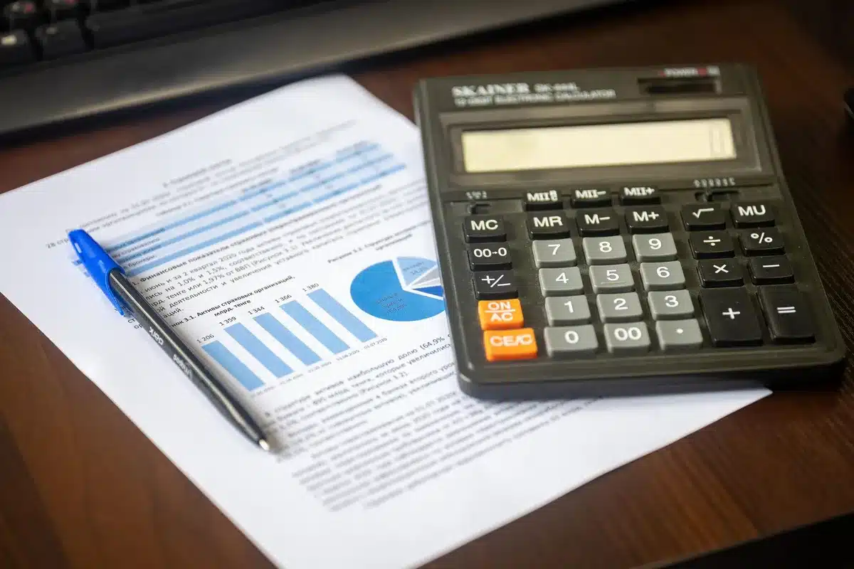 Documents juridiques, calculatrice et stylo sur un bureau symbolisant le choix des structures d'entreprise