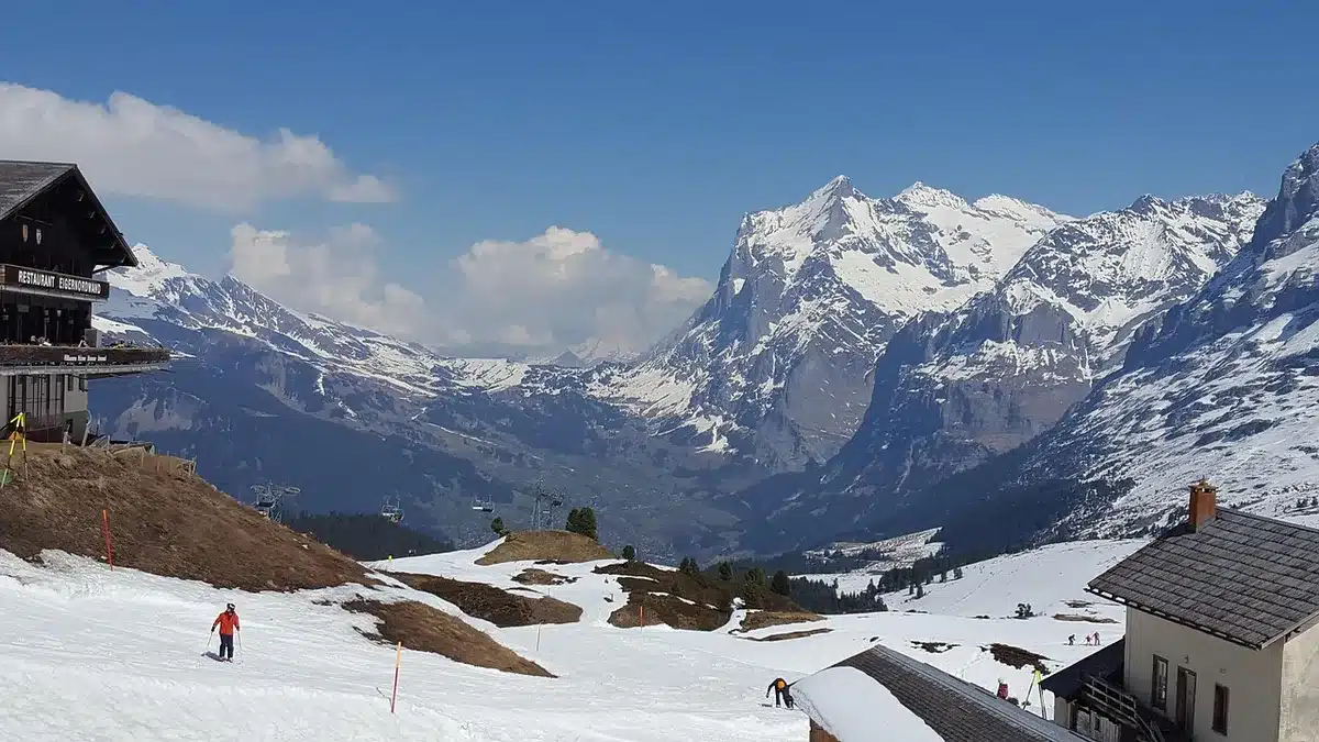 Place d'un village alpin en journée avec terrasses et ambiance conviviale