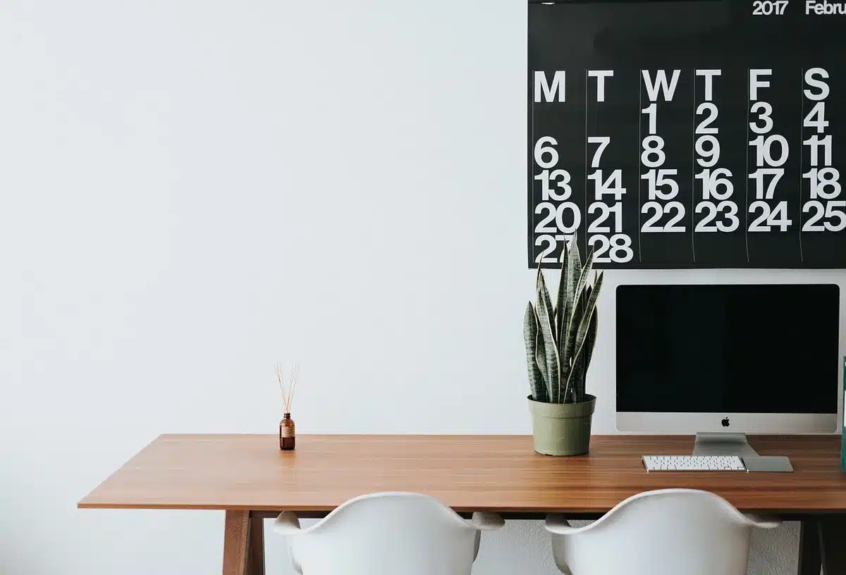 Graphiques financiers et calendrier sur un bureau éclairé par la fenêtre