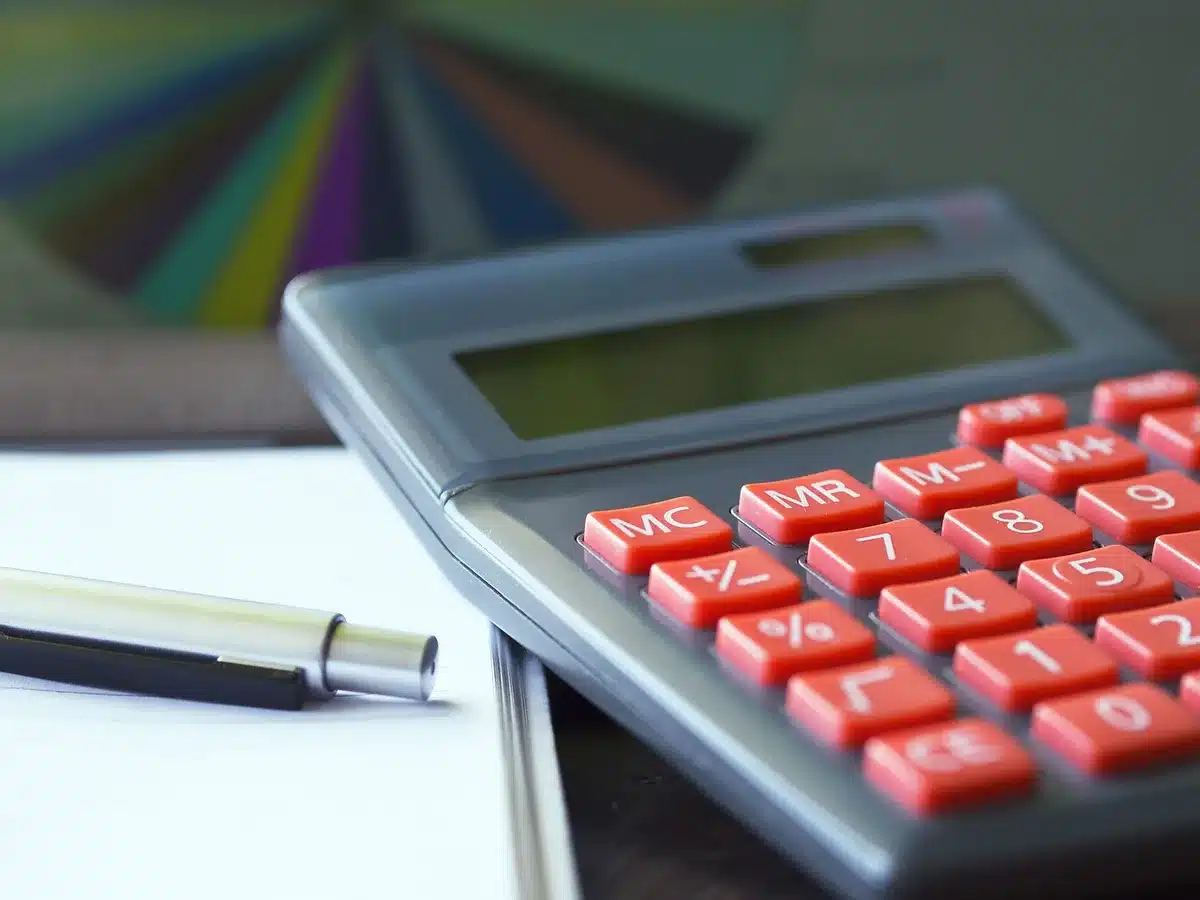Calculatrice et documents fiscaux sur un bureau pour choisir un régime d'imposition