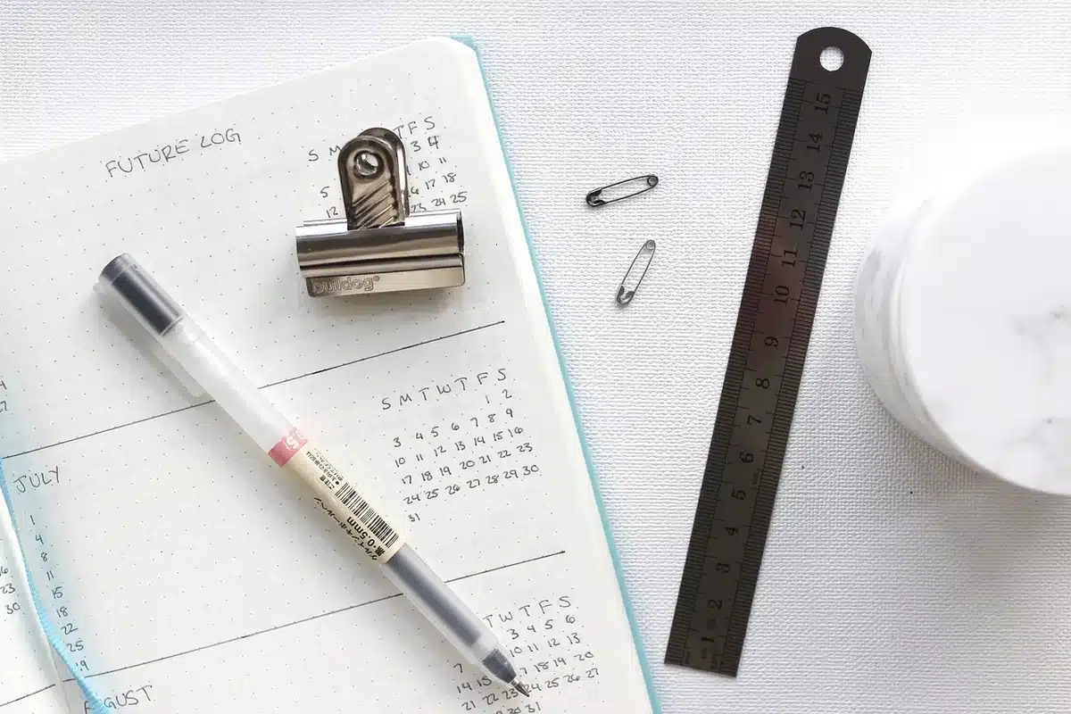 Main anonyme tenant des feuilles de contrat au-dessus d'un calendrier sur un bureau