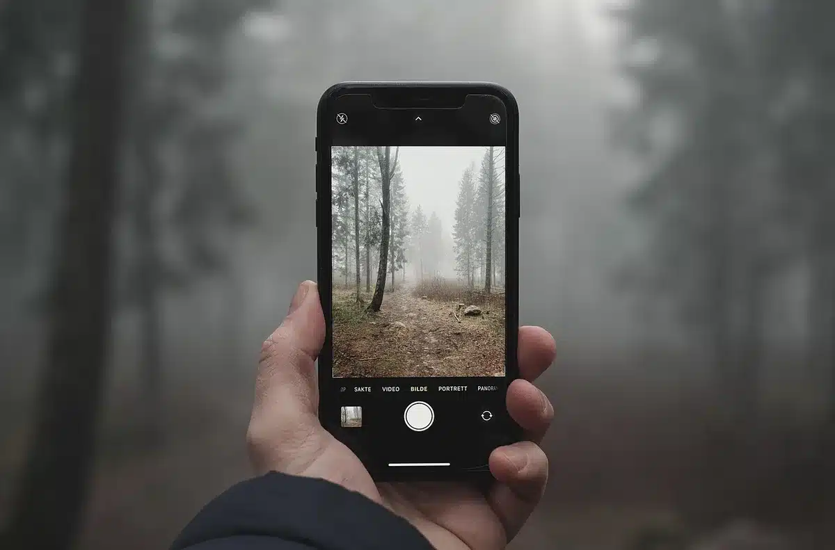 Main tenant un smartphone près d'une facture pour illustrer la résiliation d'abonnement