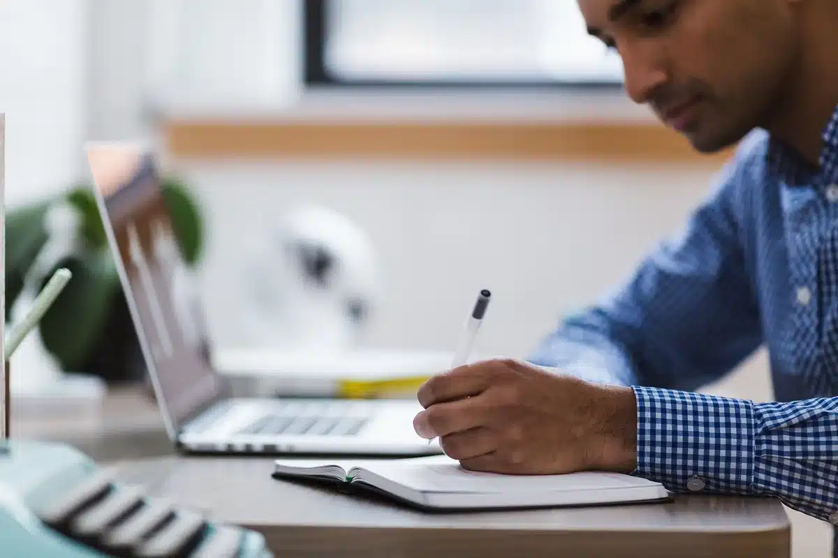 Notes et recherche de mots-clés sur un bureau avec carnet et ordinateur