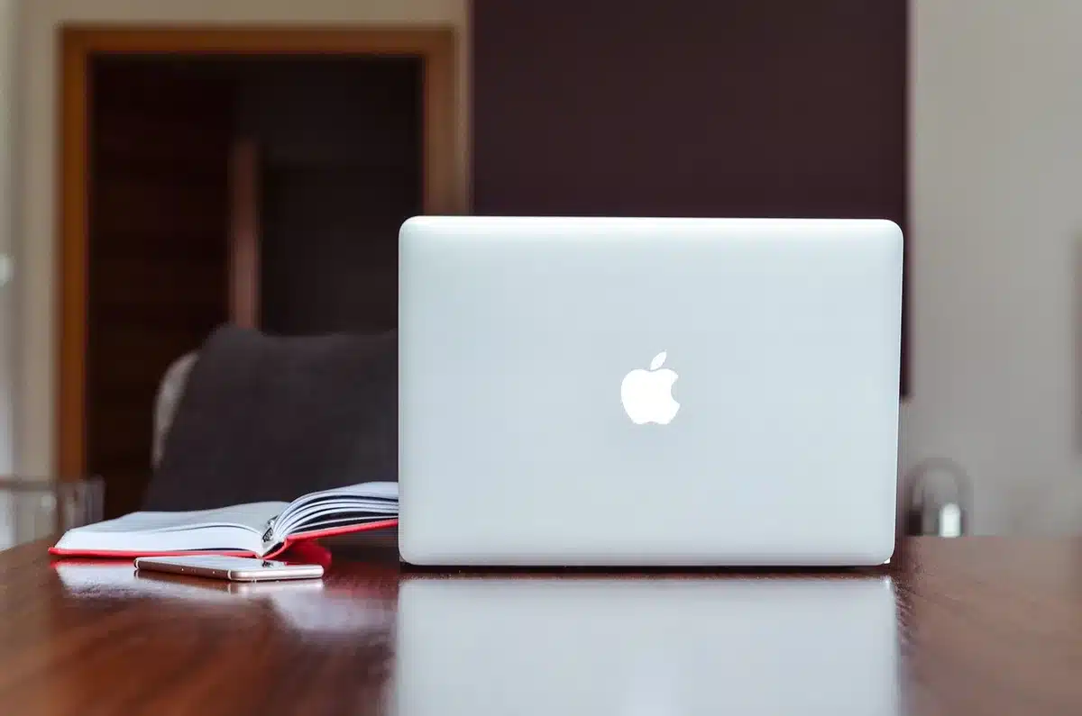 Bureau en journée avec plans techniques et appareil de mesure, mains anonymes