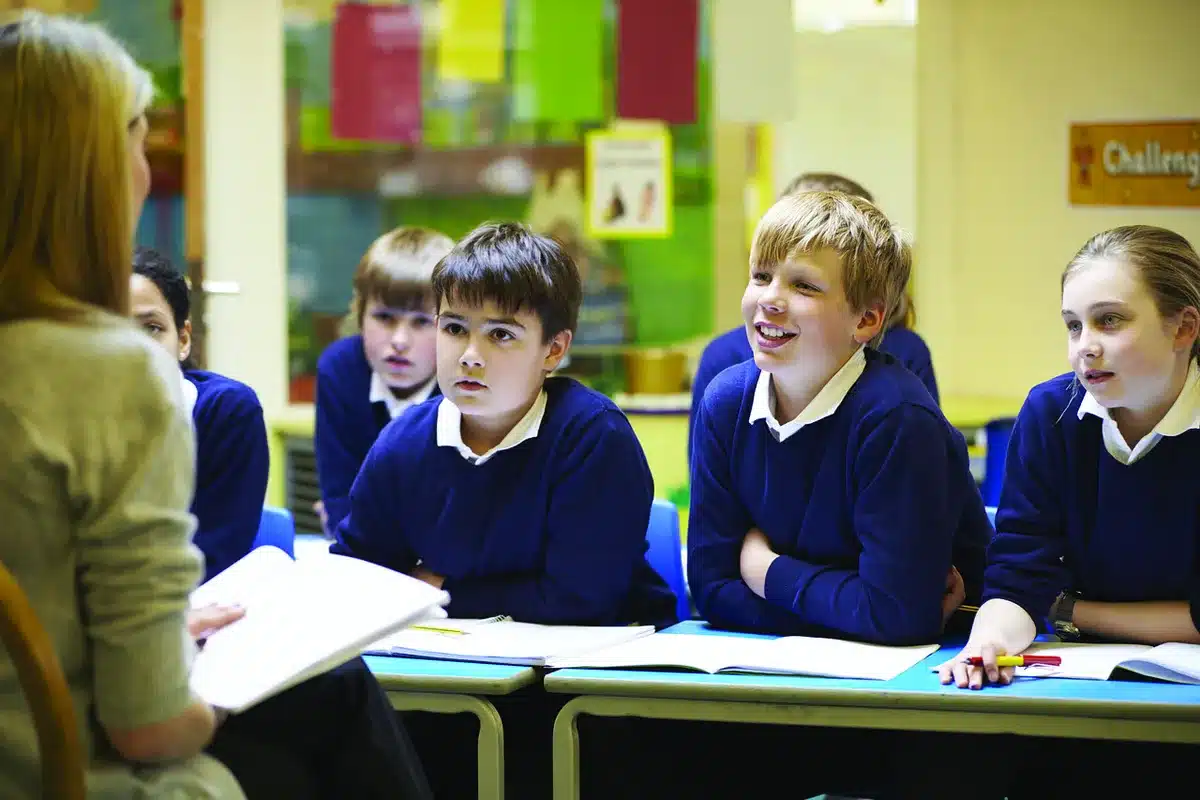 Groupe d'élèves discutant autour d'une table en classe