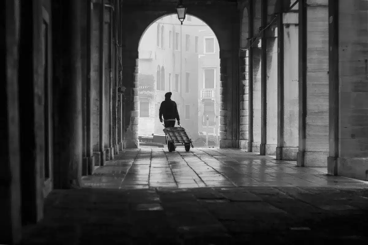 Couloir du Sénat en journée, documents et silhouettes floues discutant