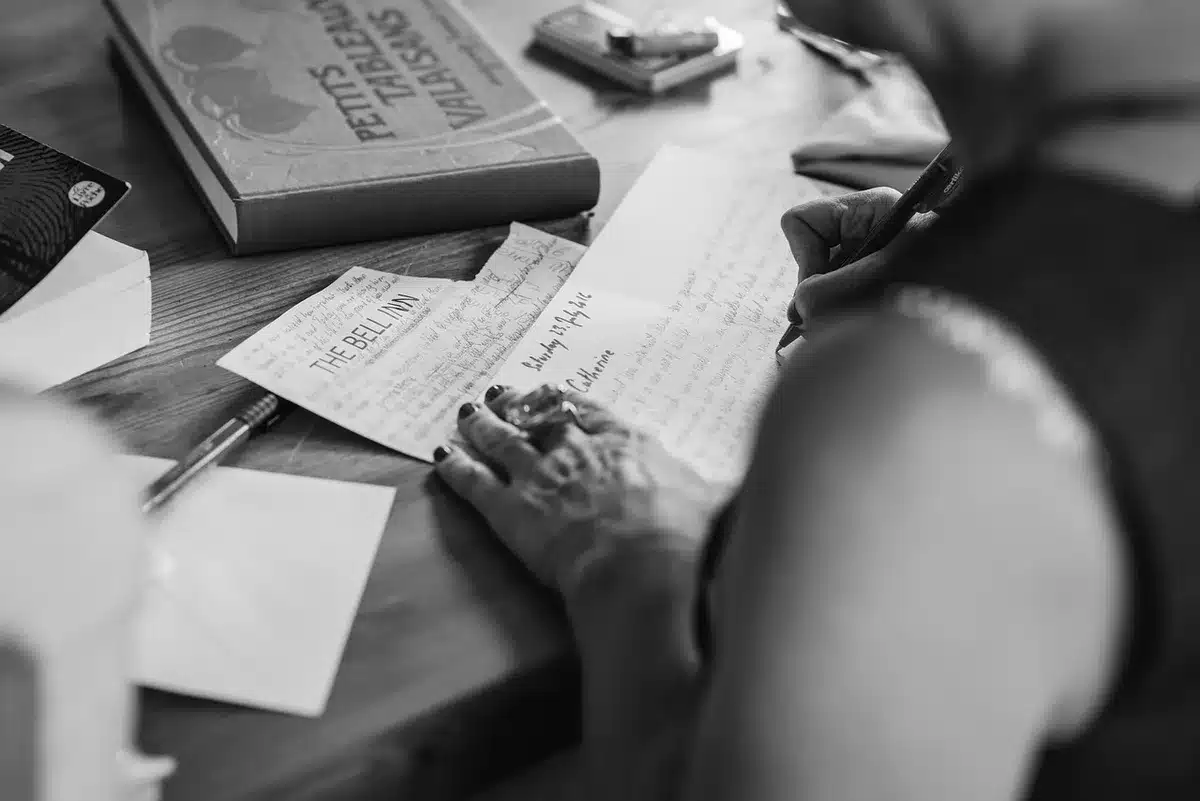 Salle de réunion en plein jour, mains anonymes feuilletant des documents et agendas