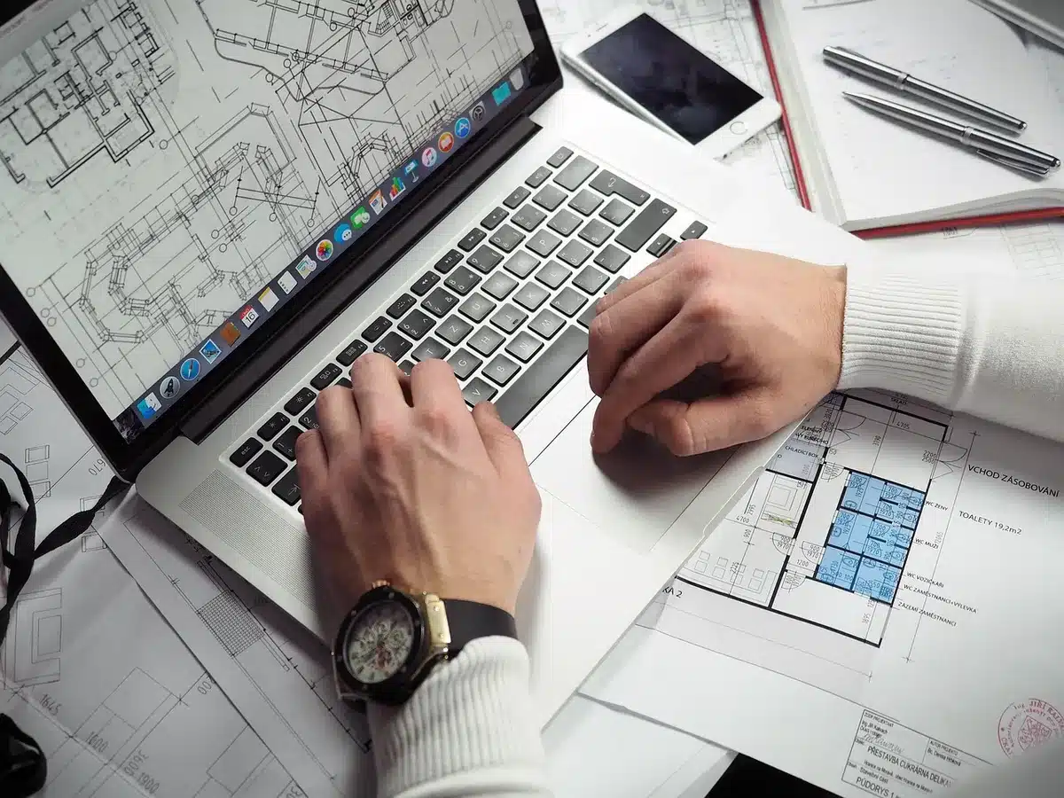 Bureau lumineux avec mains travaillant sur factures et ordinateur portable