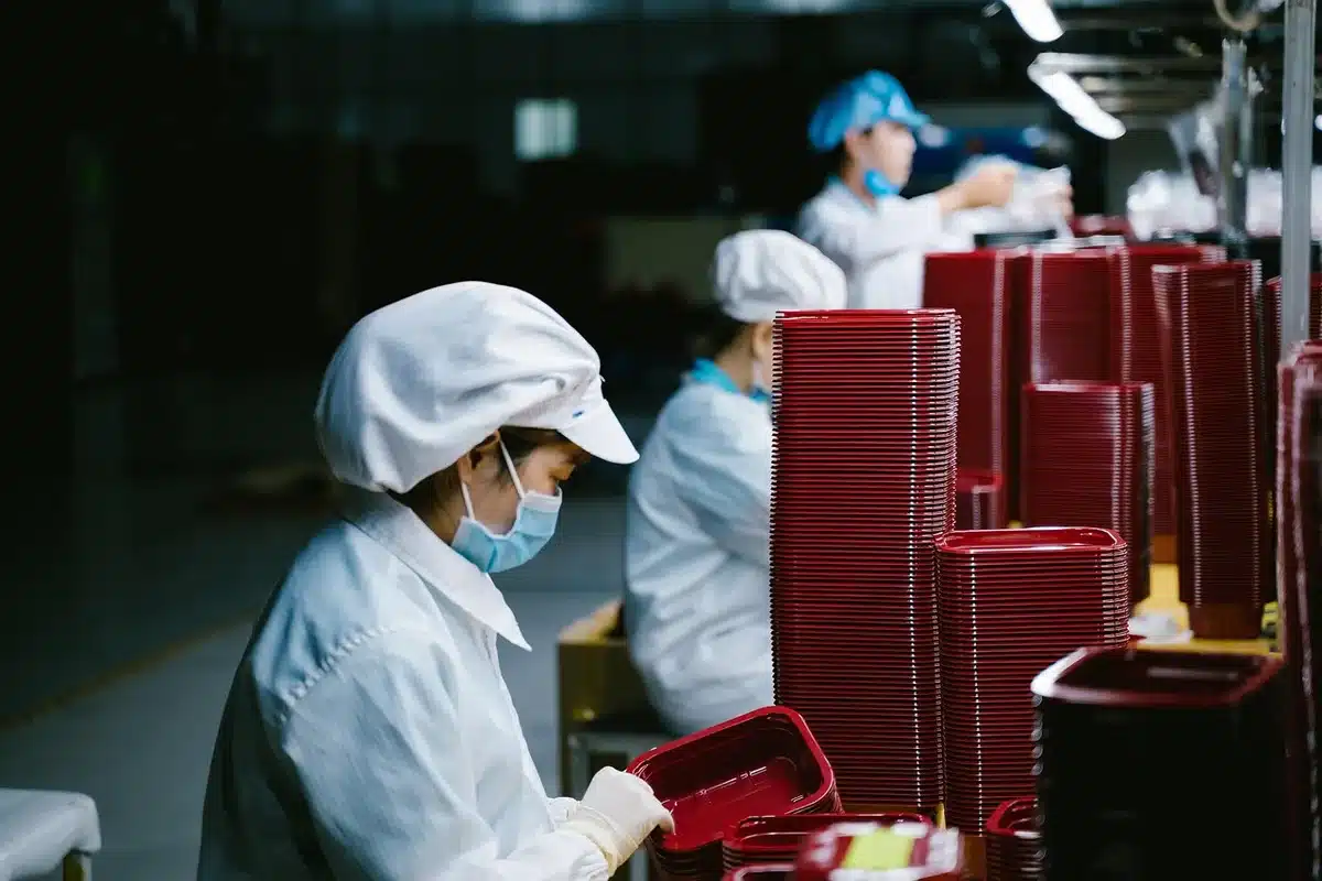 Pièces d'équipement industriel et mains autour d'une table baignée de lumière