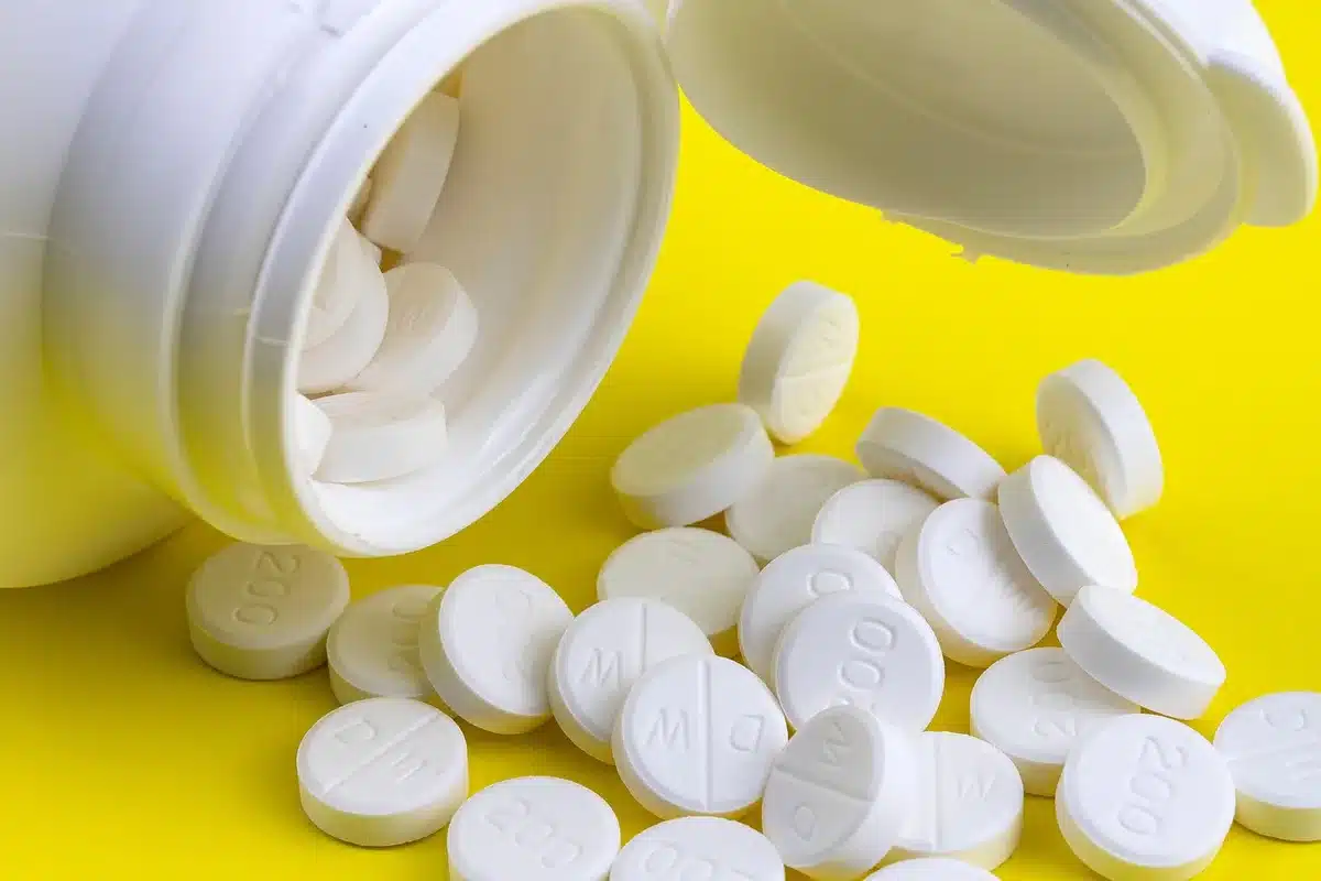 Ordonnances et boîtes de médicaments sur une table, illustrant les économies prévues sur les médicaments