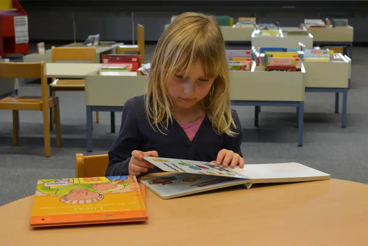 Enseignant lisant un album illustré à de jeunes élèves en classe